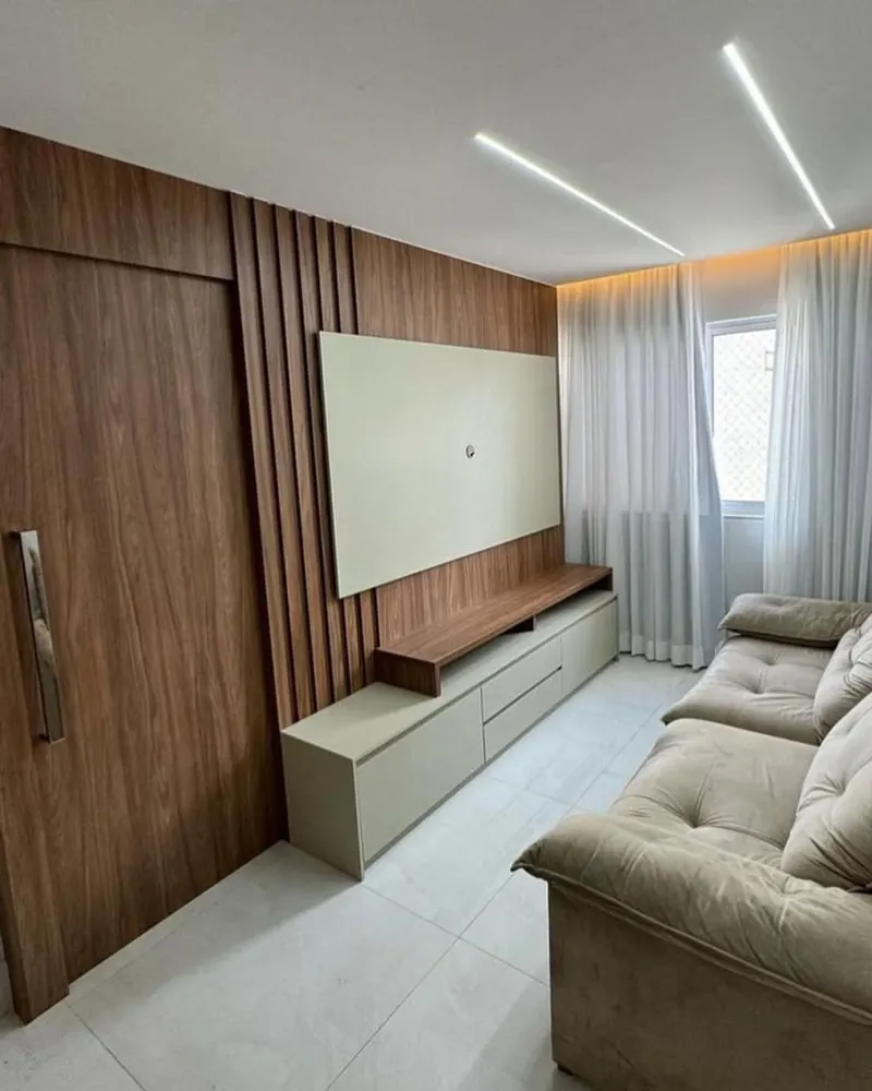 Sala de estar com painel ripado, home planejado e iluminação linear